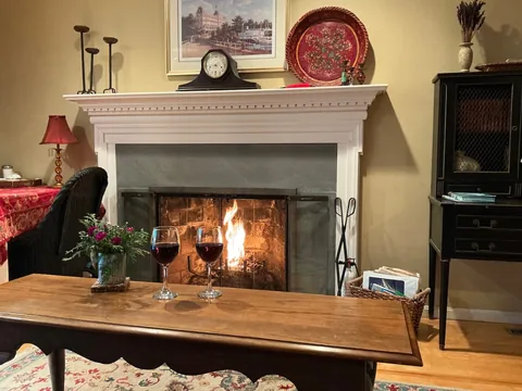 Detail of the living room fireplace with a lit fire and decorative mantel